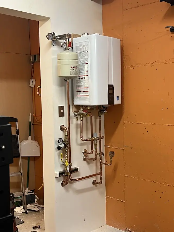 Plumbing technician inspecting water heater connections in Odenton
